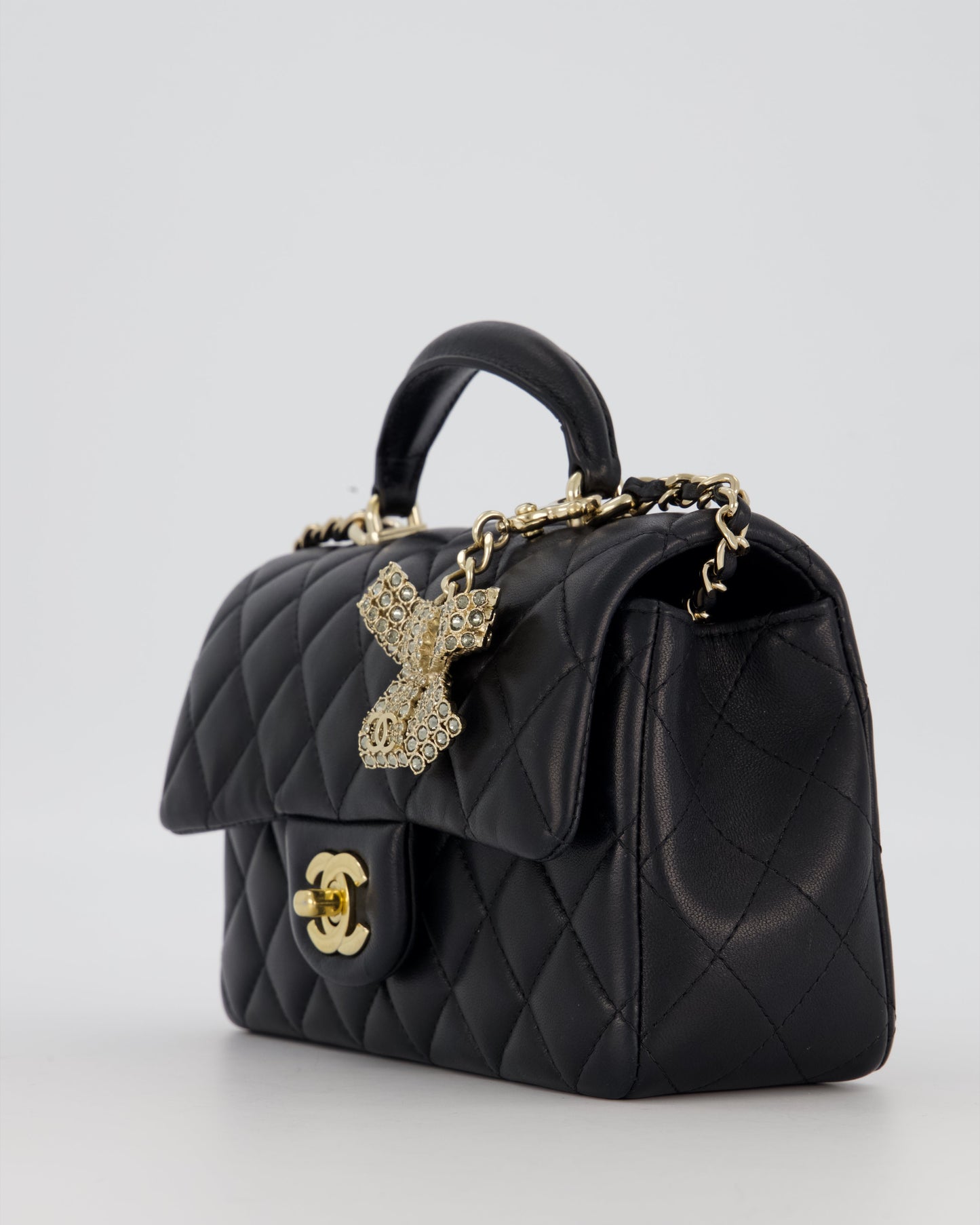 Chanel Black Mini Rectangular Top Handle Flap Bag in Lambskin Leather with Champagne Hardware and Strass Removable Bow Charm